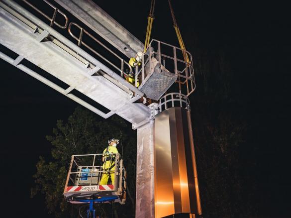 Arbeiders werken aan portiek bij nacht.