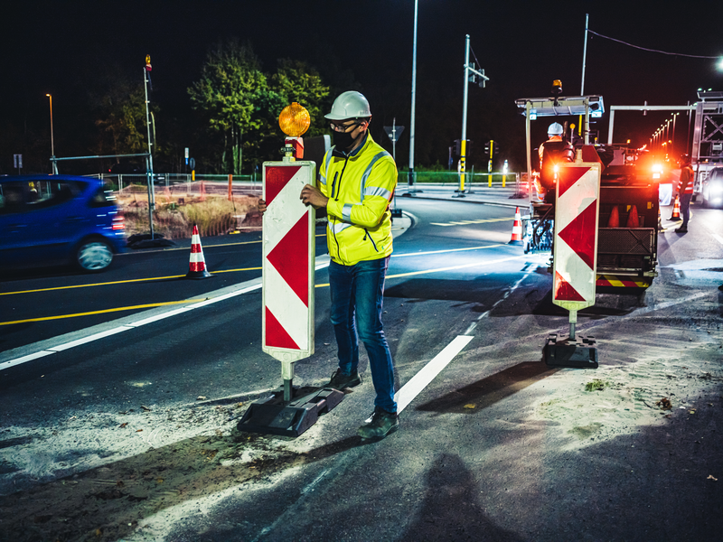 Wegenarbeider op een nachtelijke werf.